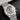 studio portrait focusing on the brown grande tapisserie dial, silver registers, vibrant orange timing hands, and date window at 4:30