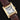A studio portrait focusing on the square silver dial, black roman numeral tracking, and blued-steel sword hands