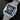 angled studio top-down view of the Cartier Santos WSSA0063 highlighting its polished bezel, exposed screws, and integrated steel link bracelet