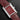 studio portrait focusing on the minimalist burgundy lacquer dial, silver sword hands, and the synthetic blue spinel cabochon crown