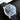 A studio portrait focusing on the blue sunray dial, gold hands, double moon phase display, tidal indicators, and date window at 3 o'clock