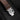 Detail of the stainless steel folding deployment clasp engraved with the JL logo on the brown leather strap