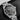 close-up studio shot focusing on the black sunray dial, white luminescent indices, date window at 3 o'clock, and the orange-tipped GMT hand