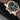 left side profile view of the rose gold case highlighting the two patented fluted screw-locked timezone adjustment pushers