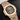 studio portrait focusing on the horizontally embossed brown dial, gold applied hands, and date window at 3 o'clock