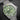 Front-angled view highlighting the distinctive green dial with horizontal ridges, octagonal hour markers, and signature yellow accents on the seconds hand