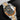 angled studio top-down view of the Tudor Black Bay GMT M79833MN highlighting its steel and yellow gold rivet bracelet and brown-black bezel