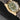 Side profile of the 18kt yellow gold Tudor Black Bay case showing the winding crown engraved with the Tudor rose
