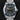 direct close-up studio front portrait of the 41mm stainless steel Tudor Black Bay 79230B featuring a matte black dial and blue bezel on a watch stand